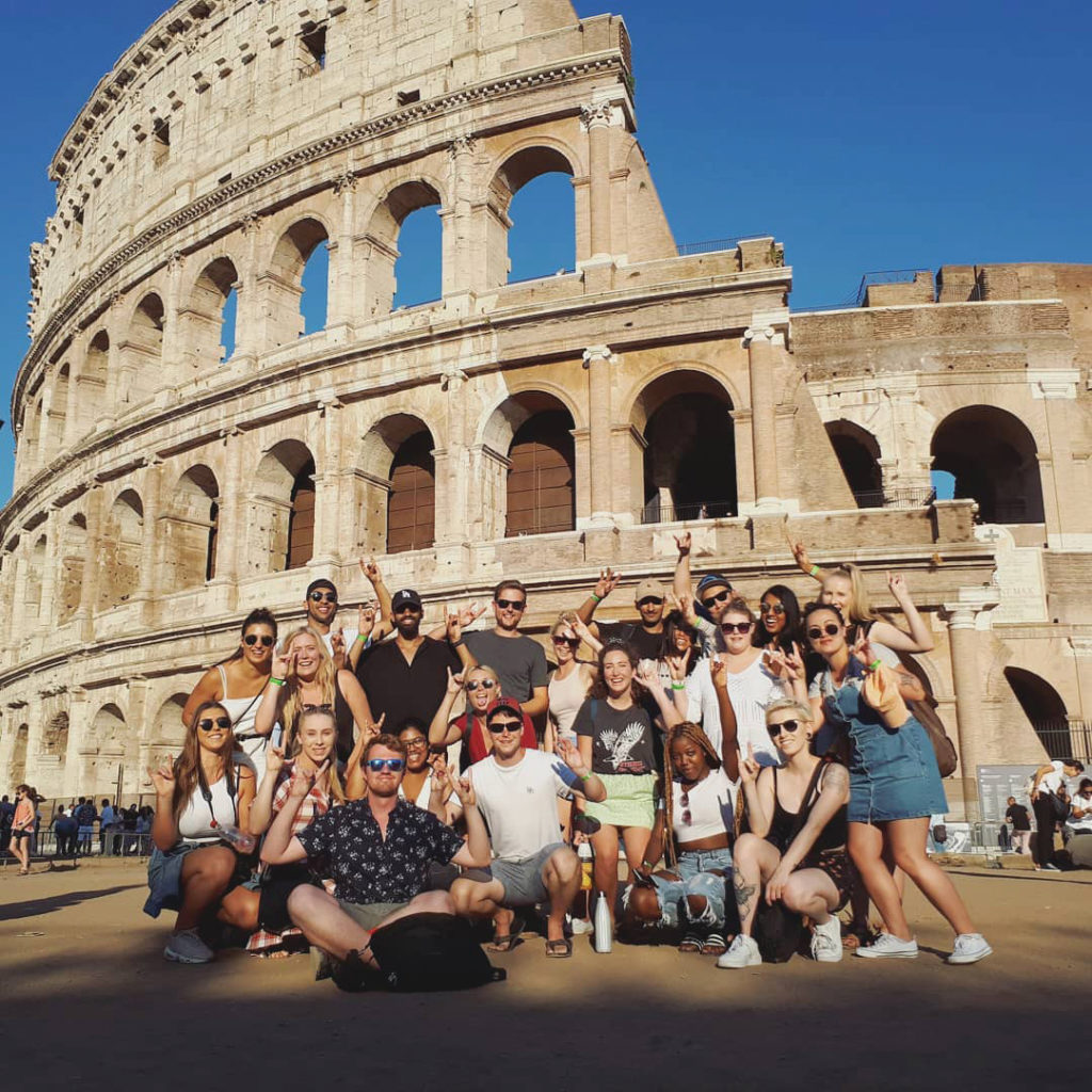 travel on a budget group photo rome colosseum 