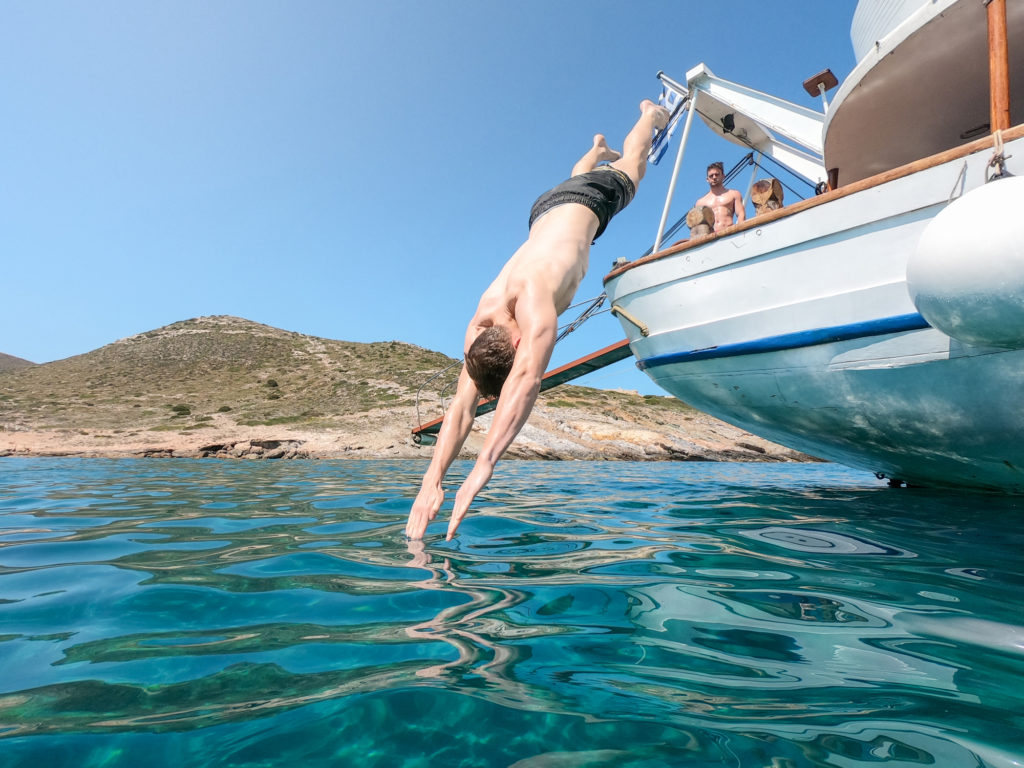 young man diving from a boat into the sea around the Greek islands