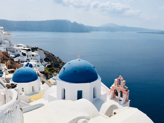 overlooking the blue-domed buildings of Santorini and the sea