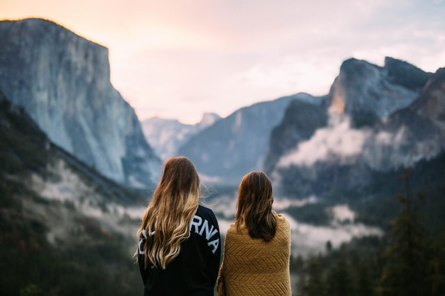 two young women looking out at a mountain scene