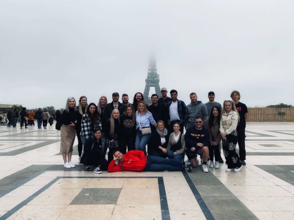 group of travellers in front of misty Eiffel Tower