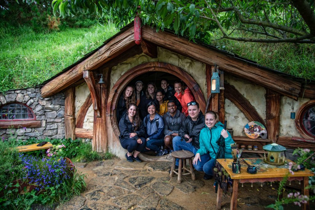Group of young travellers crowded inside a Hobbiton home.