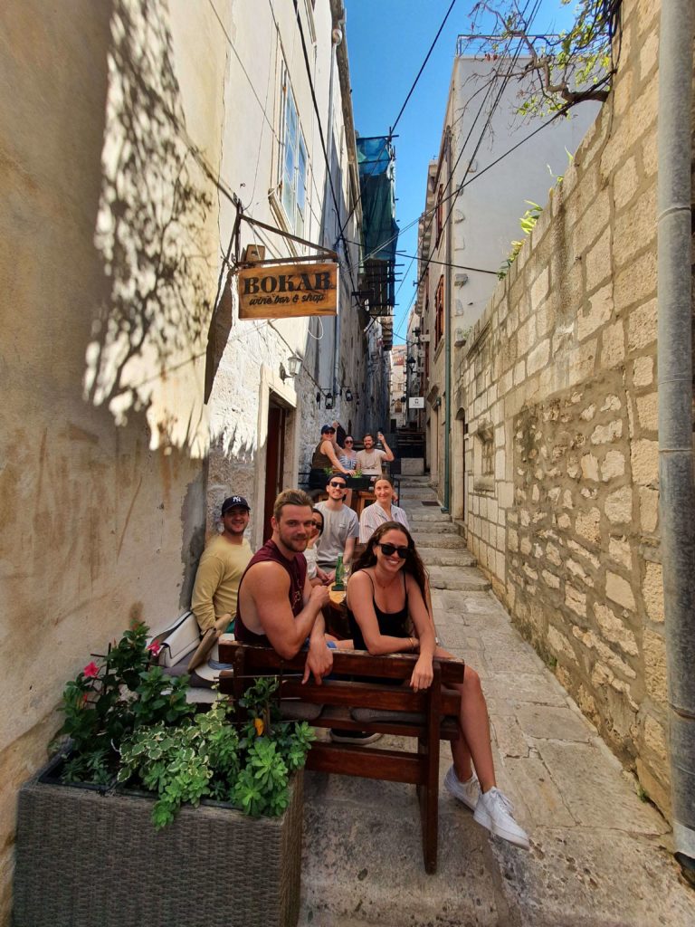 group of young people sitting in a narrow walkway