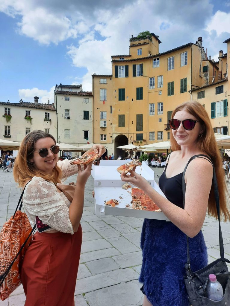 two young women posing with pizza in Italy