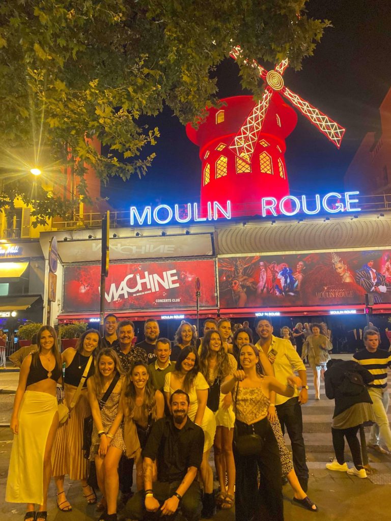 group of Topdeckers outside the Moulin Rouge in Paris at night