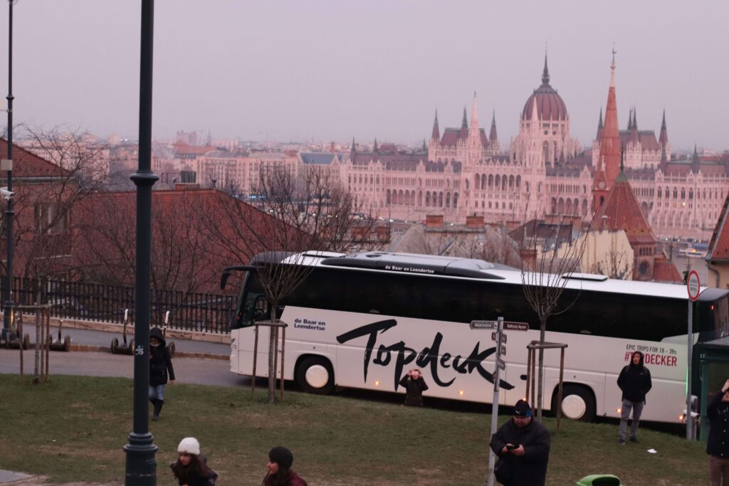 Topdeck bus in front of Hungarian Parliament Building in Budapest 