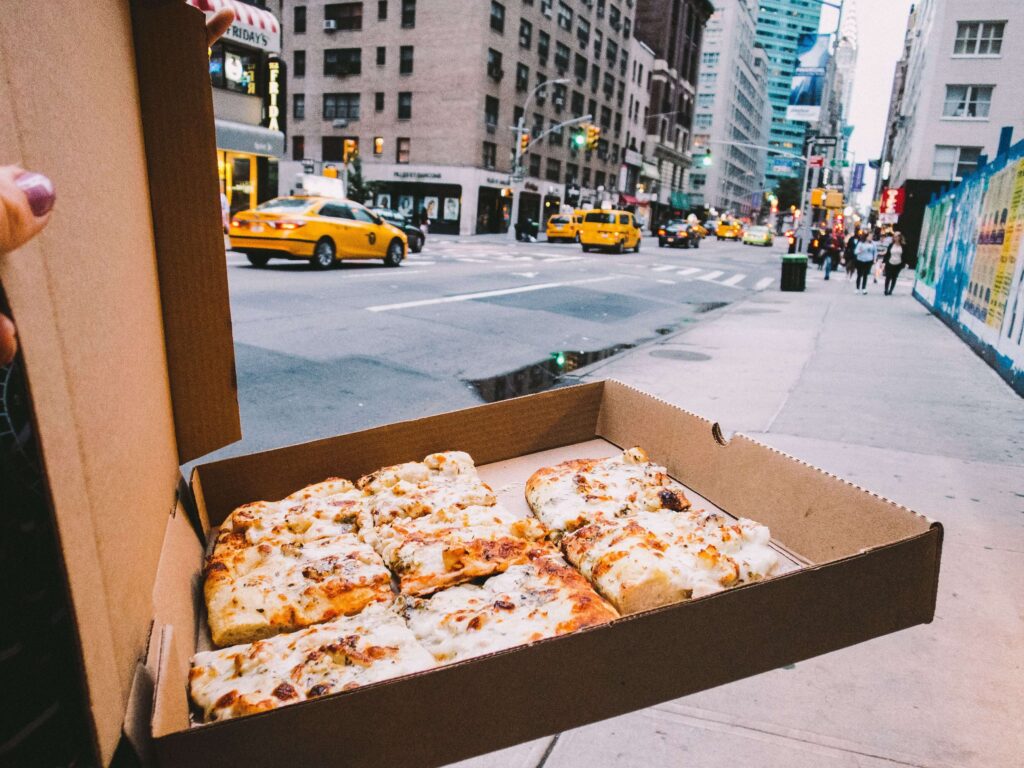 Box of square pizza on streets of New York City